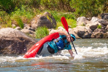Myhiya, Ukrayna - 17 Ağustos 2019: Playboating. Elinde küreklerle kayıkta oturan bir adam su üzerinde egzersiz yapar. Whitewater üzerinde serbest kayak. Eskimo rulo.