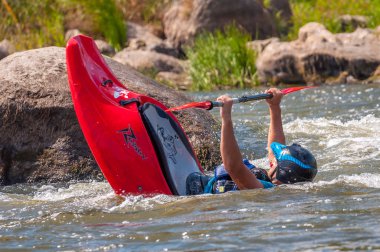 Myhiya, Ukrayna - 17 Ağustos 2019: Playboating. Elinde küreklerle kayıkta oturan bir adam su üzerinde egzersiz yapar. Whitewater üzerinde serbest kayak. Eskimo rulo.