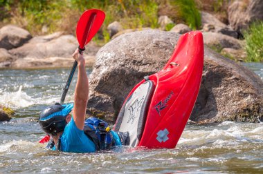 Myhiya, Ukrayna - 17 Ağustos 2019: Playboating. Elinde küreklerle kayıkta oturan bir adam su üzerinde egzersiz yapar. Whitewater üzerinde serbest kayak. Eskimo rulo.