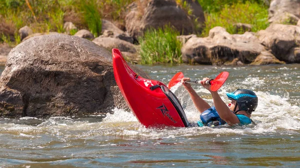 Myhiya, Ukraine - 17 août 2019 : Playboating. Un homme assis dans un kayak avec des rames à la main effectue des exercices sur l'eau. Kayak freestyle en eau vive. Rouleau esquimau . — Photo