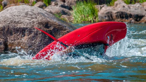 Playboating. Un hombre sentado en un kayak con remos en las manos realiza ejercicios en el agua. Kayak estilo libre en aguas bravas. Rollo esquimal . —  Fotos de Stock