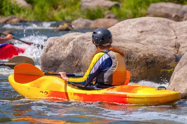 Playboating. A man sitting in a kayak with oars in his hands performs exercises on the water. Kayaking freestyle on whitewater. — Stock Photo, Image