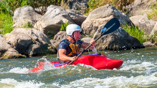 Myhiya, Ucrânia - 17 de agosto de 2019: Playboating. Um homem sentado em um caiaque com remos em suas mãos realiza exercícios na água. Caiaque estilo livre na água branca . — Fotografia de Stock