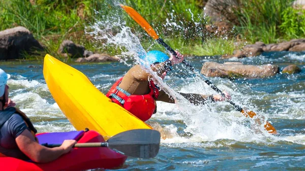 Playboating. Un hombre sentado en un kayak con remos en las manos realiza ejercicios en el agua. Kayak estilo libre en aguas bravas. Rollo esquimal . —  Fotos de Stock