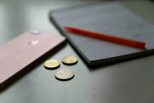 Uma Caneta Caderno Telefone Algumas Moedas Com Sobre Mesa Trabalho — Fotografia de Stock