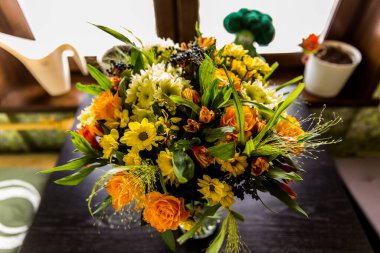 Masadaki vazoda bir buket çiçek.