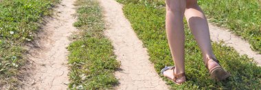 Panoramik romantik kırsal arka plan-kir yolda genç bir kadının bacakları