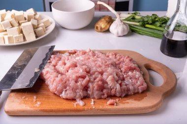 Kıyılmış et ve geleneksel Çin bıçağı Tsai DAO bir kesme tahtası ve malzemeler Mapo soya peyniri yemek için.