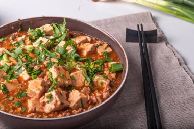 Bir keten rustik peçete üzerinde bir kase içinde kıyılmış et ve tofu peyniri ile geleneksel Çin çanak Mapo tofu