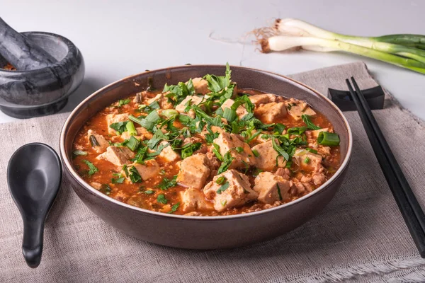 Bir keten rustik peçete üzerinde bir kase içinde kıyılmış et ve tofu peyniri ile geleneksel Çin çanak Mapo tofu
