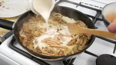 Adam tavada mantarlı yemek hazırlıyor.