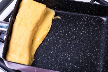 Tamagoyaki için özel bir tavada Tamago Japon omleti pişiriyorum..