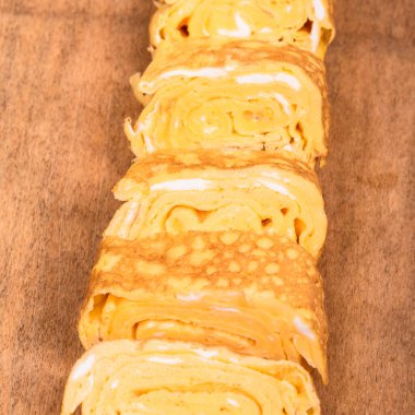 Tamago Japon omleti ahşap servis tahtasının üzerinde, yakın plan.
