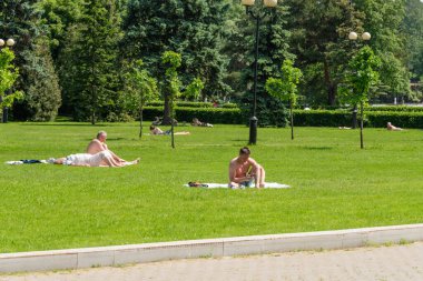 Moskova, Rusya, İzmailovsky Parkı, 11 Haziran 2020 - İnsanlar pandemik koronavirüs sırasında kendilerini izole ettikten sonra parktaki bir çayırda dinlenip güneşleniyorlar.