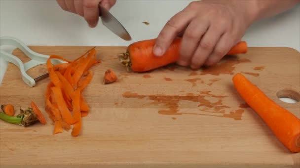 ピーラーでニンジンをむいた男 健康的な食事食品 — ストック動画