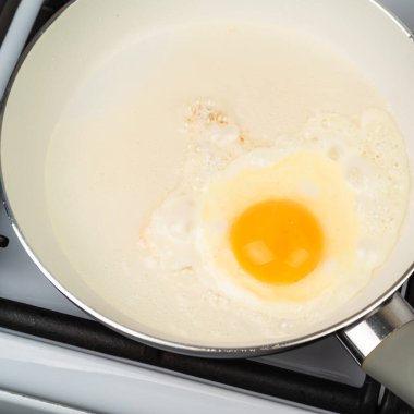 Tavada kızartılmış yumurta ve beyaz seramik yapışmaz kaplama.