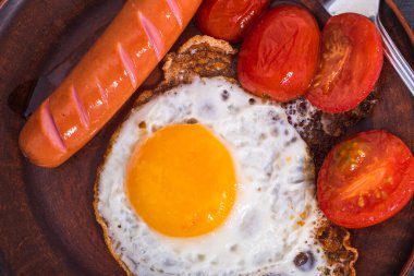 Kolayca kahvaltı, sahanda yumurta, domates ve sosis tabakta, üst manzara, yakın çekim.