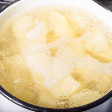 Doğranmış patatesler bir tencerede kaynatılır. Suda, yakın planda, üst tarafta.