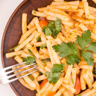 Hızlı ve basit İtalyan arrabbiata makarnası domatesli ve üzerine maydanoz serpiştirilmiş.