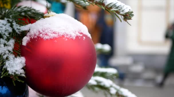 Smrkové Větve Sněhem Vánoční Hračky Červené Koule Popředí Zimní Ulice — Stock video