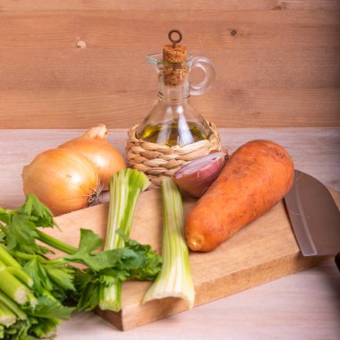 Havuç ve kereviz soğan sosu - Mirepoix ve Soffritto için zeytin yağı ve ahşap bir masa.