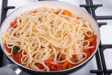 Biberli makarna ve domates soslu makarna kızartma tavasında makarna, dolmalık biber ve domatesli linguin - yakın çekim