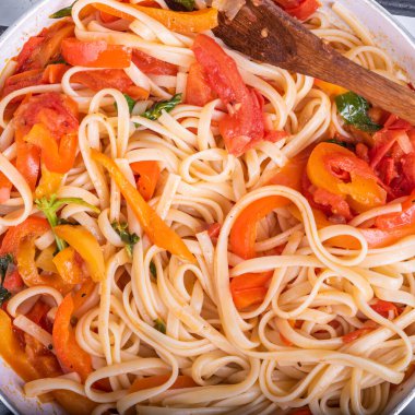 Biberli makarna ve domates soslu makarna kızartma tavasında makarna, dolmalık biber ve domatesli linguin - yakın çekim