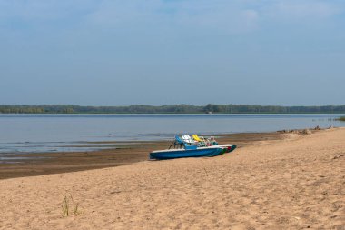 Boş bir kumsalda pedallı kürek çeken bir katamara standı. Salgın, insan yok.