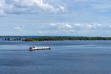 Benzin tankeri güneşli bir günde sahil boyunca yol alır.