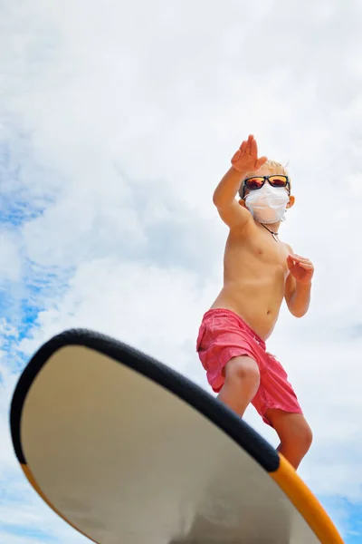 年轻有趣的冲浪选手戴着太阳镜 戴着防护面罩骑在冲浪板上 夏季海滩之旅 游轮取消 因为验尸官Covid 19流行病 探亲假的安全旅行目的地 — 图库照片