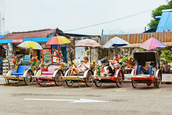 Georgetown, Penang, Malezya - 01 Eylül 2014: George Town caddesindeki klasik trishaw park yeri. Bir grup triportör şoförü dinleniyor ve şehir turunu bekliyor..