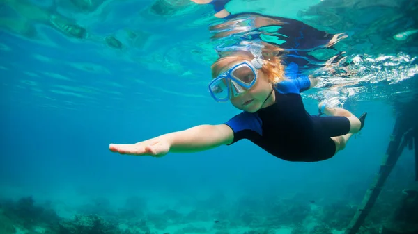 シュノーケリングマスクとウェットスーツジャンプで幸せな小さな子供は サンゴ礁の海ラグーンで水中でダイビングします 夏の冒険キャンプで家族旅行のライフスタイル 子供と一緒にビーチ休暇での水泳活動 — ストック写真