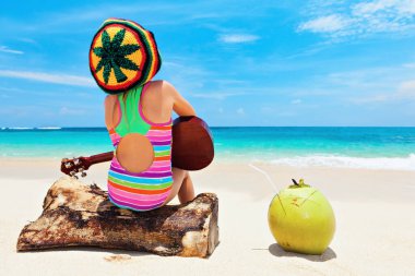 Rasta şapkalı küçük bebek Hawaii Ukulele 'sinde reggae müziği çalıyor, okyanus sahilinde dinlenmenin tadını çıkarıyor. Çocuklar sağlıklı bir yaşam tarzı. Aile yaz tatili. Tropikal Jamaika ve Karayip adaları seyahatlerinde etkinlik.