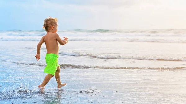 快乐的家庭在热带海滨度假胜地玩得很开心 有趣的小男孩沿着冲浪边缘在水潭边飞溅 活泼的孩子们的生活方式 人们在暑假和孩子们一起游泳 — 图库照片