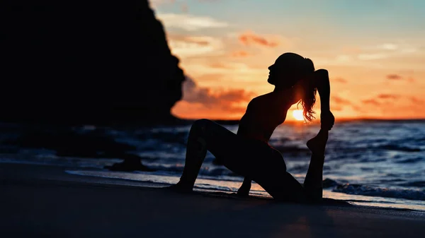 Закатном Морском Пляже Спортивная Молодая Женщина Делает Упражнения Растягиваясь Удержать — стоковое фото