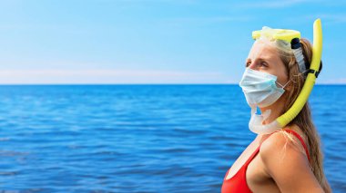 Şnorkel maskeli kız deniz sahilinde cerrahi maske takıyor. Geziler iptal edildi, Coronavirus COVID 19 dünya salgını nedeniyle turlar iptal edildi. Aile tatili için seyahat yasağı, 2020 yazında turizm sektörü krizi