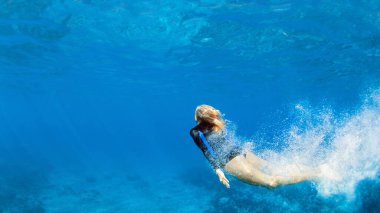 Mutlu aile - aktif genç kız tropikal mercan resif havuzuna atlayıp suya dalıyor. Seyahat yaşam tarzı, su sporu, şnorkelle yüzme macerası. Çocuklarla yaz deniz sahillerinde yüzme dersleri.