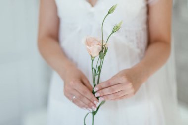 Gelin elinde güzel bir çiçek tutuyor. yumuşak odak