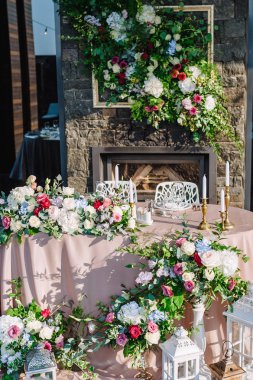 Çiçeklerle süslenmiş düğün masası.