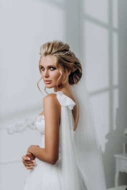 Güzel saç stili olan gelin. Beyaz iç çamaşırlı, gelinlikli model sarışın.