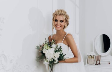 Güzel saç stili olan gelin. Beyaz iç çamaşırlı, gelinlikli model sarışın.