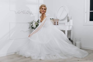 Güzel saç stili olan gelin. Beyaz iç çamaşırlı, gelinlikli model sarışın.