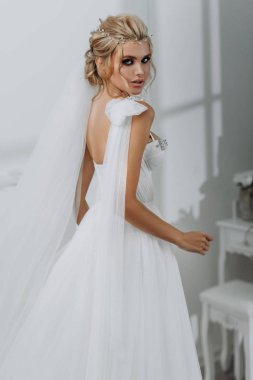 Güzel saç stili olan gelin. Beyaz iç çamaşırlı, gelinlikli model sarışın.