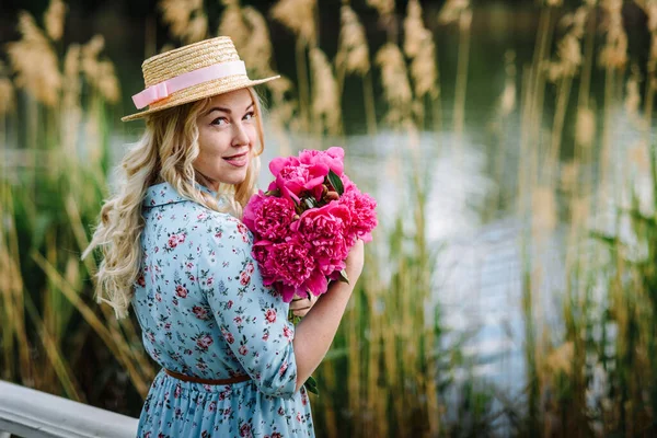 Nuori Nainen Jolla Kukkakimppu Vaaleanpunaisia Pioneja Lepää Lammen Rannalla Tyttö — kuvapankkivalokuva