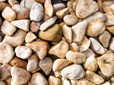 Yuvarlak taşların bej tonlarında dokusu. Tasarımcılar için yuvarlak işlenebilir taşlarla soyut bir arka plan. Güneş ışığının en üst görüntüsü.