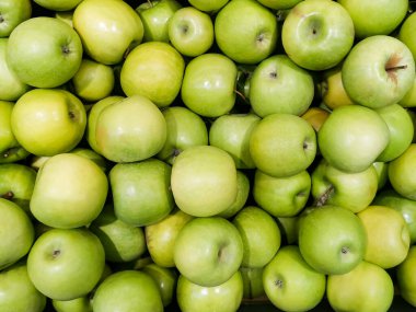Sandıktaki yeşil elmaların sağlam arka planı. Birçok organik Granny Smith elması. Süpermarkette sağlıklı ve uygun fiyatlı meyveler, dizayn için C vitamini kaynağı. Yukarıdan görüntüle.