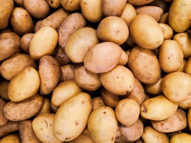 Piyasadaki soyulmamış patateslerin sağlam arka planı. Süpermarkette popüler ve uygun fiyatlı sebzeler. Patates bir mineral kaynağıdır. Yukarıdan görüntüle.
