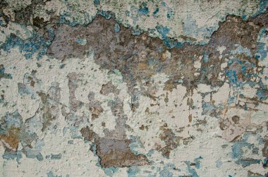 Eski, sarkık beton duvar. Mavi ve açık kahverengi gölgeli tahrip olmuş alçılı taş bir duvarın dokusu. Çatlaklar, sıyrıklar, eski boya ve alçı soyma. Eski boyanmış duvar arkaplanı.