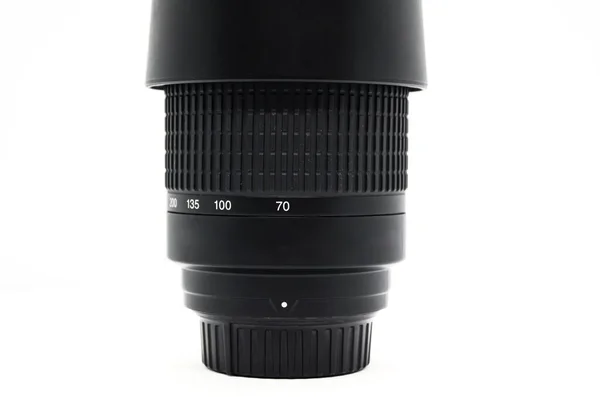 Close-up of black upright camera lens isolated on white background. Focal length adjustment scale. Photo equipment.