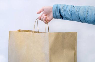 Mağazadan aldıkları kağıt torbalarla el ele tutuşan bir kadın. Mevsimlik satış ve indirim sembolü. Çevre dostu ambalaj.